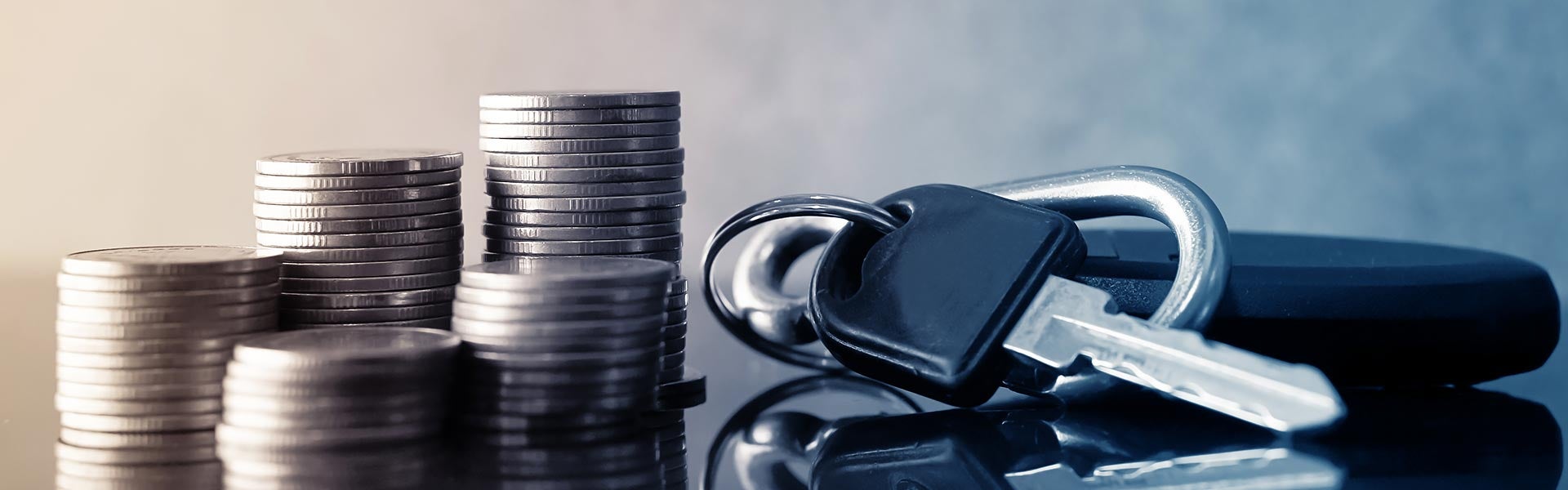 New vehicle keys lying beside stacks of coins